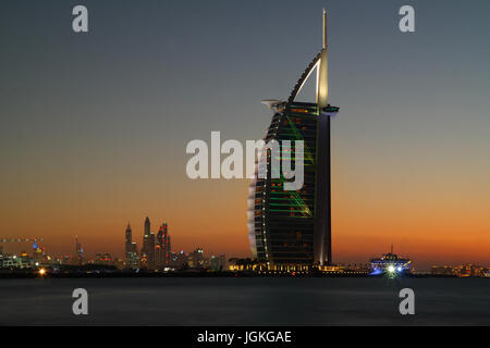 Blick auf den Sonnenuntergang auf Skyline von Dubai vom öffentlichen Strand Jumeirah, Vereinigte Arabische Emirate Stockfoto