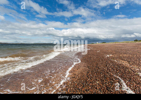 Stadt von Fortrose, Schottland. Malerische Aussicht auf die Rosemarkie Bay Strand mit Chanonry Point Leuchtturm im Hintergrund. Stockfoto