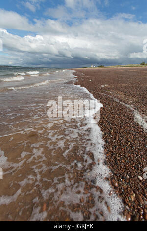 Stadt von Fortrose, Schottland. Malerische Aussicht auf die Rosemarkie Bay Strand mit Chanonry Point Leuchtturm im Hintergrund. Stockfoto