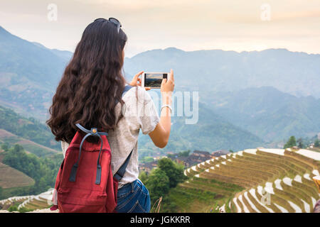 Mädchen genießen Sonnenuntergang auf terrassierten Reisfeld in Longji, Gegend von Guilin, China Stockfoto