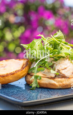 Gegrillten Ahi Thunfisch-Steak, garniert mit Rucola, serviert auf einem Brötchen Stockfoto