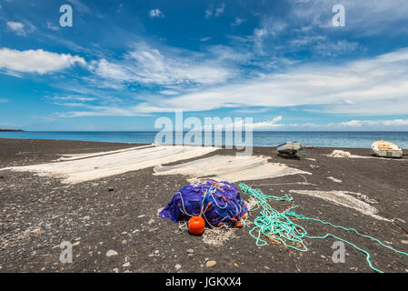 Fischernetze trocknen am schwarzen Strand auf der Insel La Réunion im Indischen Ozean Stockfoto