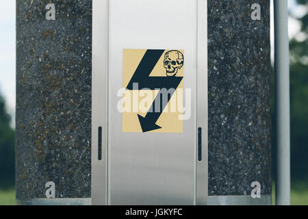 Warnschild mit menschlichen Schädel auf einem elektrischen Pol Stockfoto