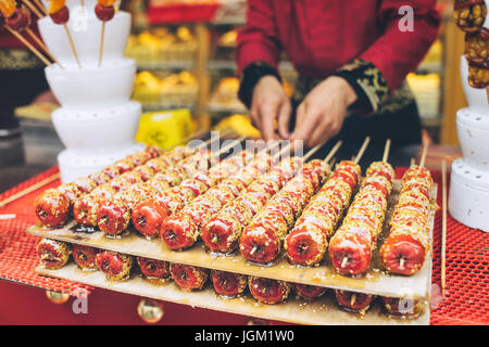 Weißdorn, eine traditionelle Zwischenmahlzeit in Peking, China. Kandierte Weißdorn Obst auf stick Stockfoto