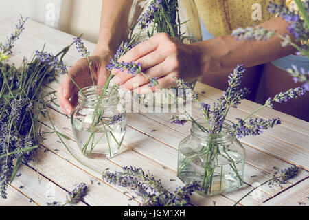 Blumengeschäft am Arbeitsplatz: kleine Blumensträuße natürliche Lavendel, aktualisieren sie im Wasser zu schaffen. Stockfoto