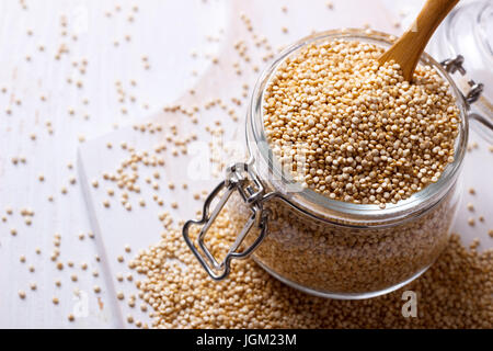 Weiße Quinoa Samen in einem Glas auf weißer Holztisch, Nahaufnahme Stockfoto