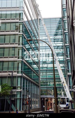 Montreal, Kanada - 25. Juli 2014: Baukran Restaurierung Sanierung durch moderne Glasbau in Innenstadt Stockfoto