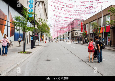 Montreal, Kanada - 26. Juli 2014: Menschen zu Fuß auf Sainte Catherine Street in Montreal Gay Village in Quebec Region mit hängenden Dekorationen Stockfoto