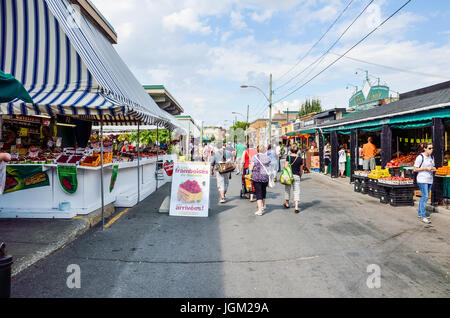 Montreal, Kanada - 26. Juli 2014: Menschen zu Fuß durch produzieren Gemüsestände außerhalb während der hellen, sonnigen Tag auf Jean-Talon Bauernmarkt mit display Stockfoto