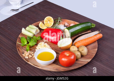 Zutaten Gemüse-Suppe mit Pesto-Sauce und Basilikum auf einer Holzplatte. Stockfoto