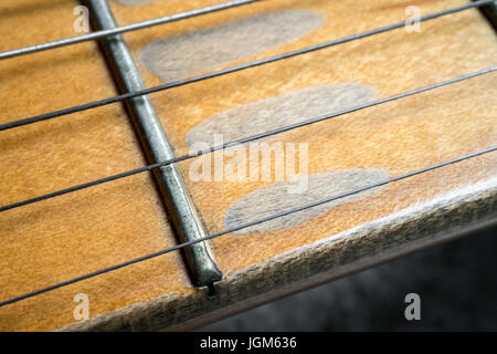 Makroaufnahme von Vintage e-Gitarre Ahornhals auf konkreten Hintergrund. Stockfoto