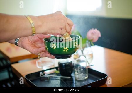 Frau Vorbereiten einer Tasse frischen Matcha Stockfoto