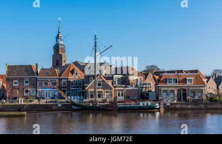 Hafen von Blokzijl in der Provinz Overijssel mit alten Schiff und im Hintergrund die Kirche und alte monumentale Häuser, Niederlande. Stockfoto