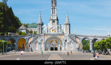 Lourdes, Frankreich, 22. Juni 2017 - Touristen zu Fuß vor der Kathedrale im Heiligtum von Lourdes, Frankreich Stockfoto