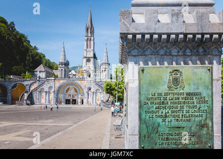 Lourdes, Frankreich, 22. Juni 2017 - Touristen zu Fuß vor der Kathedrale im Heiligtum von Lourdes, Frankreich Stockfoto