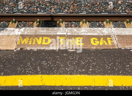 Mind the Gap Warnung in gelben Buchstaben auf ländlichen Bahnsteig gemalt, Drem, East Lothian, Schottland, Großbritannien Stockfoto
