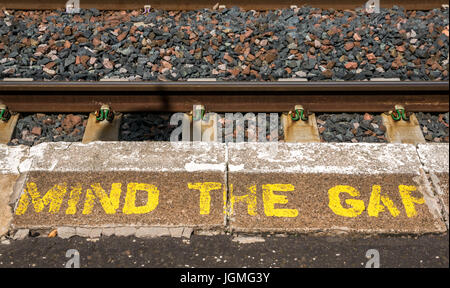 Mind the Gap Warnung in gelben Buchstaben auf ländlichen Bahnsteig gemalt, Drem, East Lothian, Schottland, Großbritannien Stockfoto