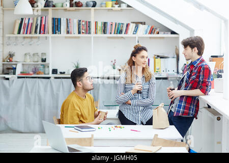 Junge Menschen, brainstorming und sprechen mit Snack und Getränke Stockfoto
