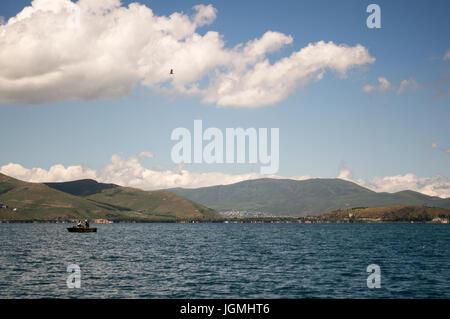 Angelboot/Fischerboot am Sewansee in Armenien mit Wolken und Berge. Stockfoto