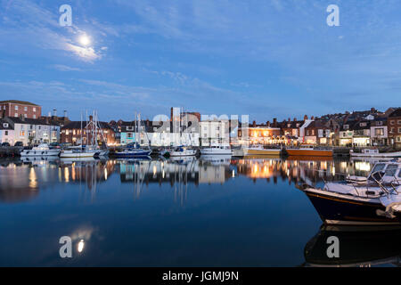Weymouth alten Hafen Dämmerung in die Nacht mit Mondlicht auf den Fluss Wey Boote und Hafen Seite bunten Häusern und Pubs, Weymouth, Dorset, England, uk, gb Stockfoto