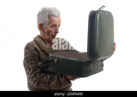 Überrascht senior Frau einen Vintage Koffer öffnen Stockfoto