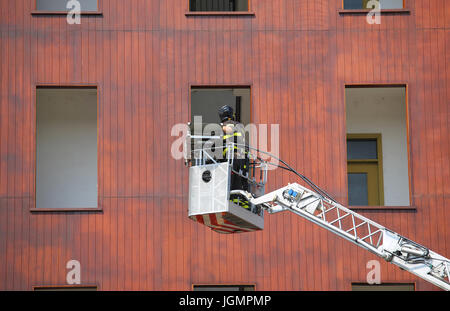 Eimer LKW mit Feuerwehr während des Trainings in die Feuerwache und das Gebäude für die Praxistests Stockfoto