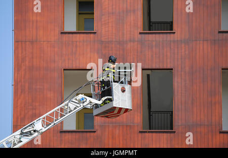 Eimer LKW mit Feuerwehr während des Trainings in die Feuerwache und das Gebäude für die Praxistests Stockfoto