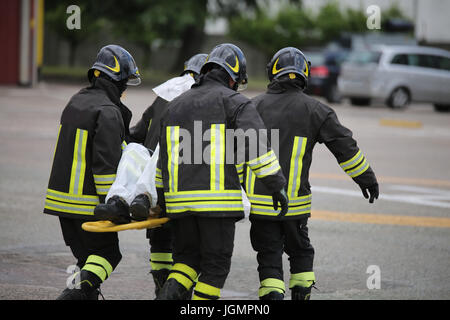 Feuerwehrleute helfen die Verwundeten mit der Bahre nach einem Verkehrsunfall