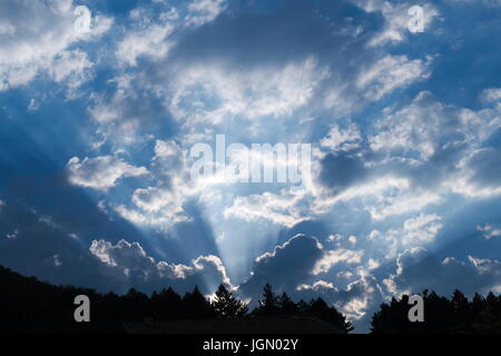 Strahlen von Licht, das durch die Wolken vor Sonnenuntergang Stockfoto