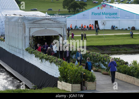 Menschen an der ersten RHS Chatsworth Flower Show (ins & kommen aus Ausstellung auf Brücke & von Festzelt) Chatsworth House, Derbyshire, England, UK. Stockfoto