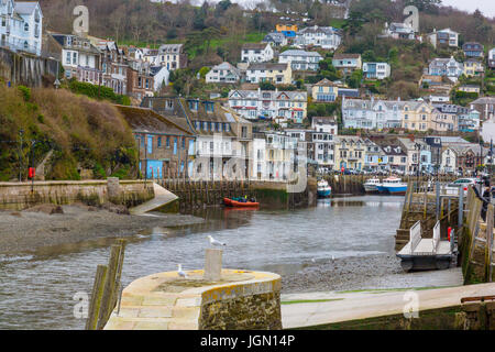 Eine Mischung aus verschiedenen Farben und den Stil der Häuser in West Looe übersehen die kleine Fischereiflotte in Looe River, Looe, Cornwall, England, Großbritannien Stockfoto