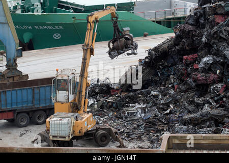 Gelbe Kran immer Schrott Autos von einem Schrott Berg am Seehafen (Pasajes, Guipuzcoa, Spanien). Stockfoto