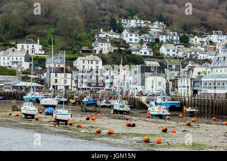 Eine Mischung aus verschiedenen Farben und den Stil der Häuser in West Looe übersehen die kleine Fischereiflotte in Looe River, Looe, Cornwall, England, Großbritannien Stockfoto