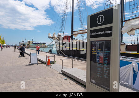 Toronto, Kanada - 26. Juni 2017: das Harbourfront Centre Schild mit einem alten Segler im Hintergrund Stockfoto