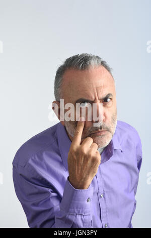 Mann mit Blick und Finger im Auge Stockfoto