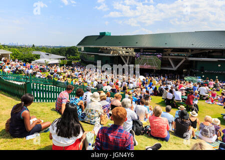 Eine überfüllte Aorangi Terrasse, bekannt als 'Henman Hill' bei heißem Wetter und Sonnenschein, wie Menschen ein Match in Wimbledon Tennis Weltmeisterschaften 2017, UK sehen Stockfoto