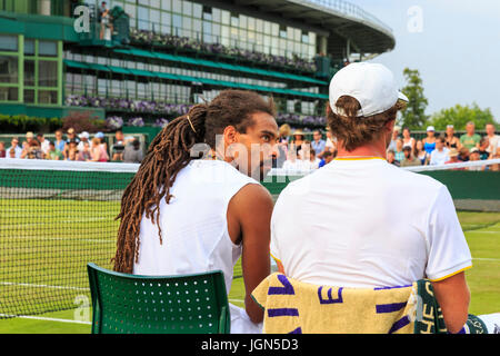 Deutsche Tennisspieler Dustin Brown und Mischa Zverev sprechen Taktik während ein Herren Doppel-Match in Wimbledon Tennis Weltmeisterschaften 2017, ganz England Stockfoto