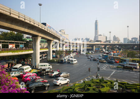 Verkehr auf zufahrtsstraßen an Victory Monument, Kreisverkehr, mit Fußgängerweg und BTS Skytrain am Viadukt Overhead. Bangkok, Thailand Stockfoto