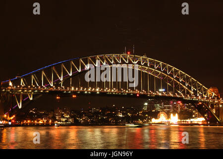 Beleuchtete Sydney Hafen-Brücke über Meer in der Nacht Stockfoto