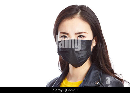 junge asiatische Frau trägt schwarzen Maske, starrte in die Kamera, isoliert auf weißem Hintergrund. Stockfoto