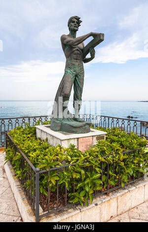 GIARDINI NAXOS, Italien - 28. Juni 2017: Skulptur L' Uomo e il Mare (Mann und das Meer) am Wasser in Giardini-Naxos-Stadt. Giardini Naxos ist am Meer r Stockfoto