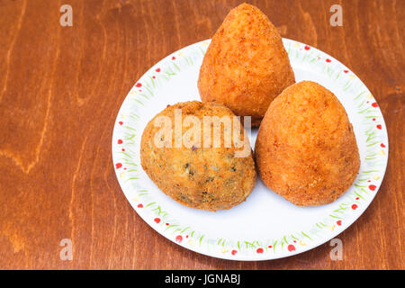 traditionelle sizilianische Streetfood - Reis verschiedene Kugeln Arancini auf Platte auf Tisch Stockfoto