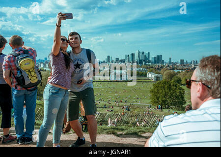 Junges Paar nimmt ein Selbstporträt mit Canary wharf im Hintergrund. Stockfoto