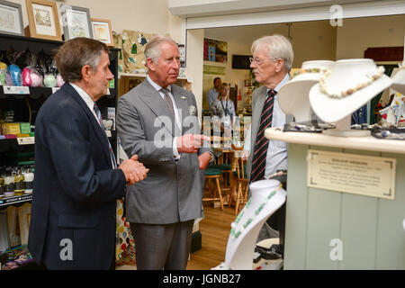 Der Prinz von Wales (Mitte) sieht rund um den Shop in Myddfai Community Hall in Myddfai, Llandovery, vor Enthüllung ein neues Glasfenster zum Thema der walisischen Legenden, erstellt von der lokalen Bevölkerung bei. Stockfoto