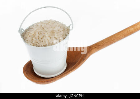 Vollen Eimer Reiskörner steht in einem Holzlöffel. Das Konzept von Lebensmitteln. Stockfoto