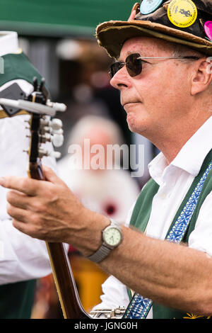 Kaukasische Mann, 40s, Folk Musiker, spielen Banjo aus der Maldon Greenjackets Morris Seite. Close Up, Hinsetzen mit Banjo in seinen Schoß. Stockfoto