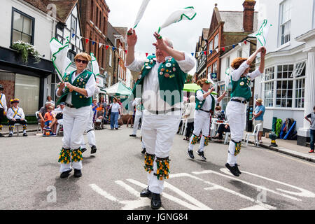 Traditionelle englische Volkstänzer, Maldon Greenjackets Morris Seite tanzen auf der Straße in der mittelalterlichen Stadt, Sandwich während des Folk und Ale-Festival. Wirbelnden weißen und grünen Taschentücher um, als sie einen Tanz aufführen. Stockfoto