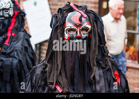 Volkstänzer aus Wilde Jagd Morris Gruppe, die traditionelle rote und schwarze Gesichtsmaske, die in früheren Zeiten verwendet zu verstecken, wer sie waren. Close Up, Kopf und Schultern. Stockfoto