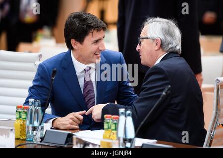 Der kanadische Premierminister Justin Trudeau plaudert mit EU-Kommissionspräsident Jean-Claude Juncker vor dem Start der dritten Plenarsitzung am Finaltag des G20-Gipfeltreffens im Congress Center Hamburg Handel 8. Juli 2017 in Hamburg, Deutschland.   (OMT‑Beschlüsse/Güngör über Planetpix) Stockfoto