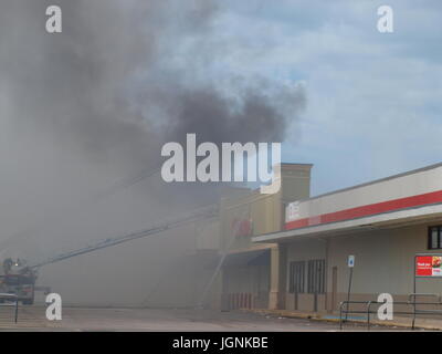 Dallas, USA. 8. Juli 2017. Feuerwehrleute arbeiten 6 Alarm Blaze. Ein mehrere Alarm Feuer konnte 25 Meilen entfernt gesehen. Die Temperaturen waren in den hohen 90er Jahren mit Hitze-Indizes im dreistelligen Bereich. Rauch war auch ein kritisches Element, wie Feuerwehrleute galten mit Atemschutzmasken und mit Muskelathropie. Copyright Credit: Dallaspaparazzo/Alamy Live-Nachrichten. Bildnachweis: Dallaspaparazzo/Alamy Live-Nachrichten Stockfoto